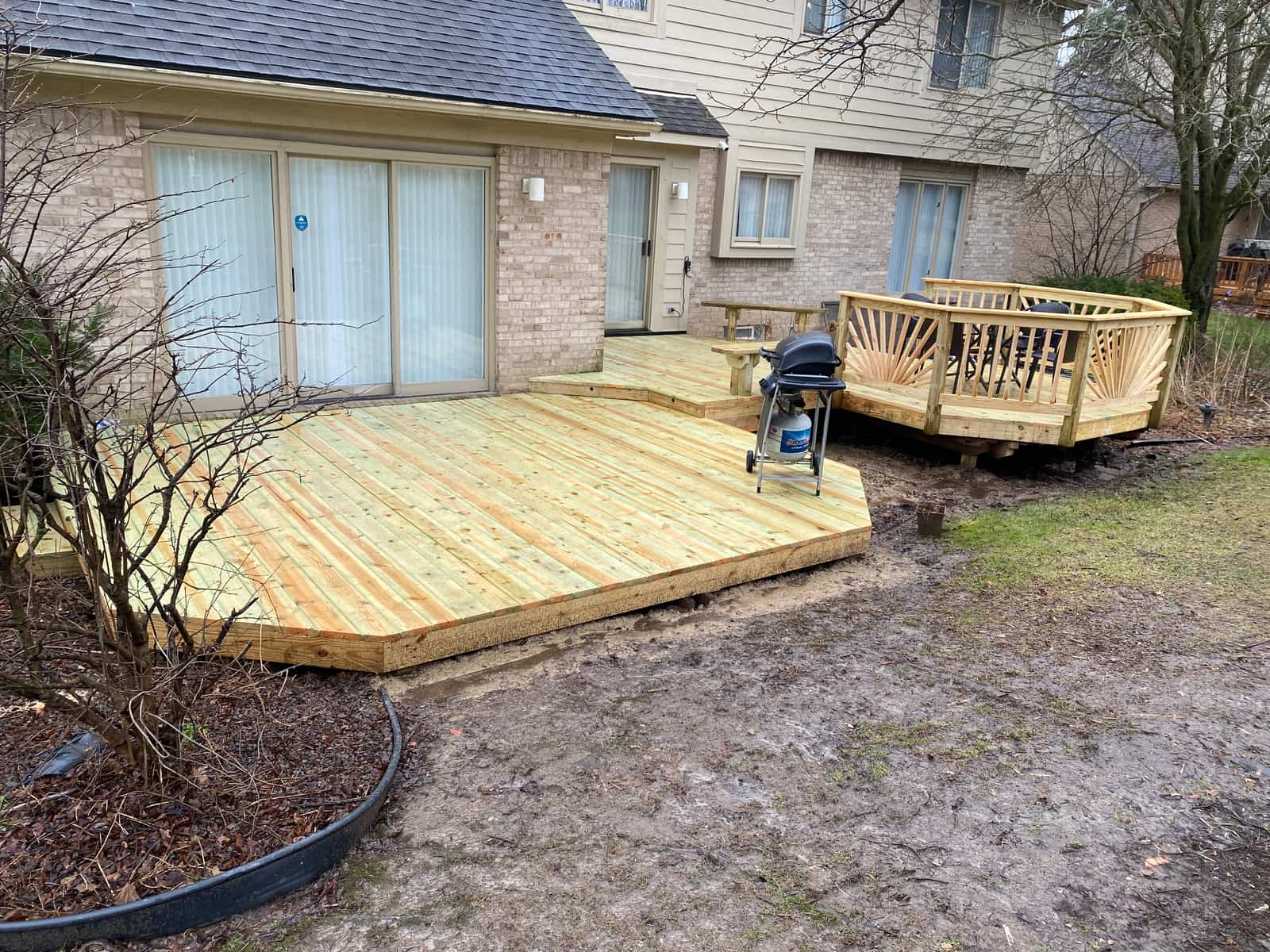 Finished deck surface and rebuilt railing viewed from the yard in Novi